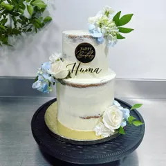 A pretty cake for a pretty human. This two-tiered semi-naked cake is filled with our signature three-berry compote and lemon curd, and decorated with fresh flowers for a beautiful birthday celebration.