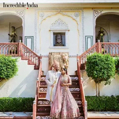 A feature by Incredible India, showcasing a royal wedding portrait on the steps of a majestic palace in Jaipur.