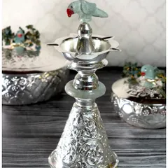 Intricately crafted and full of character, this standing diya from my Jade Parrot collection features a silver-plated lamp topped with a carved jade parrot.