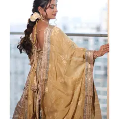 A view from the back, showcasing the intricate hairstyle and the beautiful drape of her golden dupatta. Every detail is carefully considered to create a cohesive and stunning look.