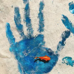 This piece, 'The Human Imprint', uses a simple handprint on a tote bag to send a message about our impact on the oceans. The small fish swimming within the print is a reminder of what's at stake.
