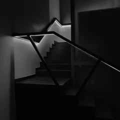 The play of light and form on a modern staircase. We used integrated LED lighting within the handrail to create a dramatic, graphic effect, turning a functional element into a piece of light art.