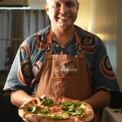 Looking to elevate your next house party? I provide exclusive pizza catering with contemporary Neapolitan style pizzas that will wow your guests. Here I am with a freshly baked pie, ready to be served.