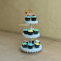 A three-tiered stand filled with colorful Cocomelon-themed cupcakes.