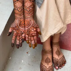 A complete semi-bridal look, showing the coordination between the hand and feet mehendi. The feet feature a simple but elegant mandala design.