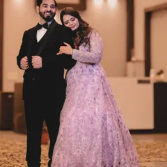 A stylish and classic portrait from a reception. The bride rests her head on the groom's shoulder as he stands confidently in his tuxedo. This pose is elegant and timeless, perfectly capturing the formal yet intimate feel of the celebration.