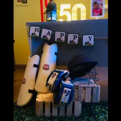 Details from the cricket-themed decor. We used the cricketer's own gear, like his SS pads and helmet, as authentic props, displayed on rustic wooden crates to enhance the theme.