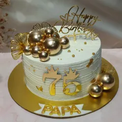 Celebrating 75 years with a touch of gold. This cake is adorned with a cascade of golden spheres, fan details, and a prominent "75" topper, making it a truly grand centerpiece for a papa's special day.