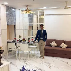 Here I am in a recently completed living and dining area. You can see how the foldable dining table integrates seamlessly with the overall design, complemented by a large mirror wall that enhances the sense of space.