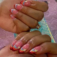 Let your nails show your playful side. This custom design features a modern rainbow French tip on a sheer pink base, accented with tiny, hand-painted daisies for a cheerful and unique look.