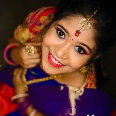A joyful, top-angle shot that captures the complete bridal look, from the maang tikka to the radiant smile. The eye makeup is sharp and the lip color pops beautifully.