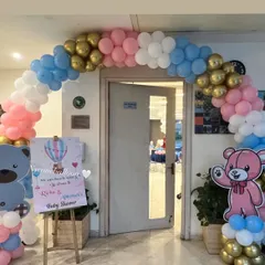 Welcome your guests in style with a themed entrance arch. This balloon arch for a teddy bear baby shower uses pink, blue, and gold balloons and includes a personalized welcome sign for the parents-to-be.