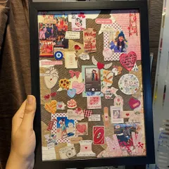 A closer look at this personalized couple's frame, held to show its size and detail. You can see the layers of photos, love notes, and custom icons that make it a truly unique anniversary or Valentine's Day gift.