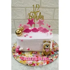 Celebrating a special milestone with a half-birthday cake. This adorable design features a teddy bear, pink stars, and a "1/2 Birthday" topper.