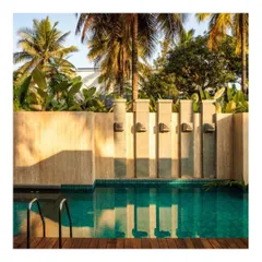 The swimming pool is designed as a tranquil corner for escape. The stone water spouts and wooden deck create a resort-like feel, embedding relaxation into the home's design.