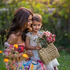 A beautiful, sun-drenched moment between actress Shriya Saran and her daughter Radha. The flowers, the soft light, and their loving interaction create a portrait that feels joyful and idyllic, a perfect memory of a mother's love in a garden.