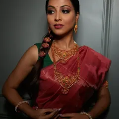 A full view of a classic South Indian bridal look. The makeup, hair, and styling all come together to honor the rich traditions, from the temple jewelry to the elegant braided hairstyle.