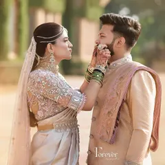 A playful and romantic moment. The groom wears a custom pastel sherwani with a matching dhoti, a modern fusion look that is both elegant and comfortable for a pre-wedding photoshoot.