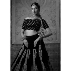 A timeless black and white portrait of the model in a traditional lehenga. This artistic choice emphasizes the texture, embroidery, and powerful silhouette of the bridal attire.