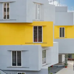 The facade of a CBSE School in Bengaluru, where symmetry and color are used to create a playful yet orderly learning environment. The projecting window bays in grey and yellow add a sense of rhythm to the building.