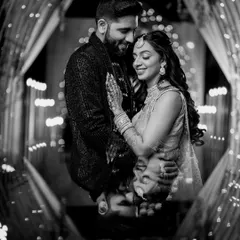 A timeless black and white portrait from Zaee and Kartik's Sangeet, framed by the beautiful, glowing lights of the decor.