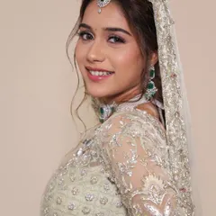 A soft and dreamy look created for a photoshoot. The pastel green lehenga is complemented by shimmery eye makeup and a natural lip, perfect for a bride who wants an ethereal and modern Nikkah or reception look.
