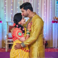 A tender moment between the couple during their Haldi ceremony. The groom kisses the bride's forehead, showing a quiet connection amidst the celebration.