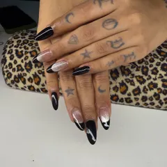This set combines a few different styles, including a sharp black French tip and a glitter accent nail. It's a great example of how you can mix and match designs for a custom look.