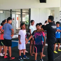 Correcting posture is a key part of my coaching. Here, I'm making a hands-on adjustment to ensure this young client understands proper body alignment for safe and effective movement.