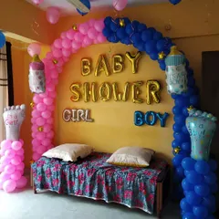 This is a classic 'Boy or Girl' themed baby shower decoration. I used a split design with pink and blue balloon arches and themed foil balloons to build excitement for the big reveal.