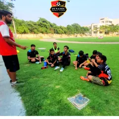A coach leads a post-practice discussion with the team. These moments are crucial for reflection, learning, and strengthening the bond between players and mentors.