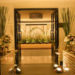 The entrance to a grand celebration, framed by tall banana plants and elegant mirror consoles. This view promises a stunning decor experience right from the moment guests walk in.