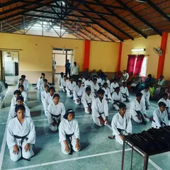 Students kneeling in seiza, waiting for the black belt grading exam to begin. This moment is filled with nervous anticipation and reflects the formal discipline of traditional karate.