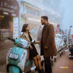 A candid, moody shot of a couple sharing a moment on a scooter on the foggy Mall Road in Mussoorie. This highlights our ability to capture authentic, street-style romance during a destination couple shoot.
