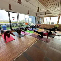 A wider view of our corporate mat session. Practicing together as a team helps build camaraderie while allowing each individual to work on their personal strength and flexibility. Notice the focus and engagement of each participant.