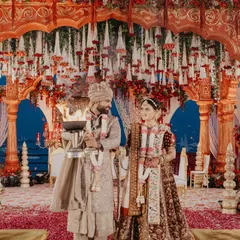 The couple participating in the Ganga Aarti, a divine and sacred part of their wedding ceremony. We ensure these significant traditions are photographed with reverence and beauty.
