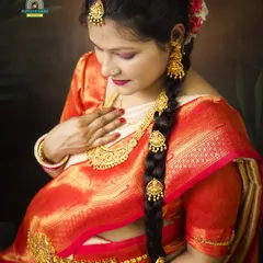 A close-up shot highlighting the intricate details of the traditional jewelry and the radiant glow of the expectant mother during her South Indian themed maternity session.