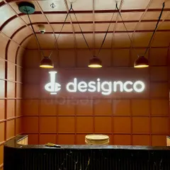 For the DesignCo office, we used lighting to reinforce their brand identity. The backlit signage creates a bold focal point at the reception, while suspended pendants provide functional, warm light over the desk, making the entrance both impressive and welcoming.
