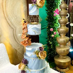 A stunning five-tier wedding cake with a beautiful blue marble effect and gold accents. The floating tiers in the middle add a modern, architectural element, making it a true work of art.