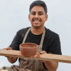 A student proudly holds up his first-ever wheel-thrown bowl. Our instructors provide step-by-step guidance to ensure that even beginners can create a well-shaped piece in their first session.