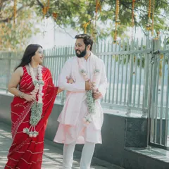 The newly married couple taking a walk after their court ceremony. Dressed in simple yet elegant attire, their happiness is the main focus of this beautiful, sunlit shot.