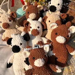 A whole herd of our chunky yarn crochet cows! We offer them in different color patterns like classic black and white, brown and white, and even pink. Each one comes with a little floral crown for extra cuteness.