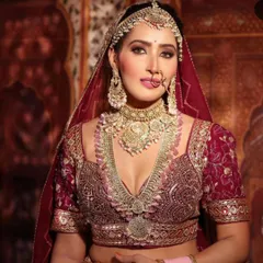 This close-up captures a majestic bridal look with a heavy, multi-layered Polki rani haar and choker against a rich maroon blouse, perfect for a traditional wedding portfolio.