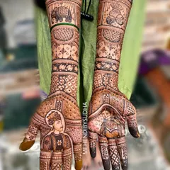 This is a perfect example of a full bridal story mehendi. On the palms, we have beautiful portraits of the bride and groom, while the arms feature auspicious elephant motifs and traditional wedding symbols.