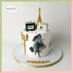 A chic, Parisian-themed cake for the stylish birthday girl. This design features an illustration of a fashionista, edible shopping bags from Zara and Michael Kors, and a golden Eiffel Tower topper.