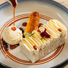 A caramel sauce pour over a tres leches cake. Action shots like this add a dynamic, mouth-watering element to dessert photography.