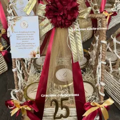 A close-up of the 25th-anniversary hamper. It contains five jars of customizable eatables, a personalized card, and is beautifully decorated with a large floral bow and a wooden '25' cutout.