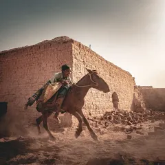 A young worker gallops through a brick kiln in rural Bihar, kicking up a cloud of dust in the golden light. This environmental action shot tells a story of energy and perseverance, capturing the motion of daily life in a challenging landscape.