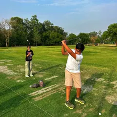 A young golfer shows off his follow-through while his friend looks on. We're passionate about nurturing the next generation of golfers.