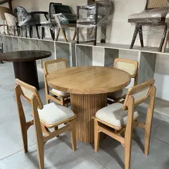 Another view of the light wood dining set, showing the texture of the bouclé fabric on the chair seats.